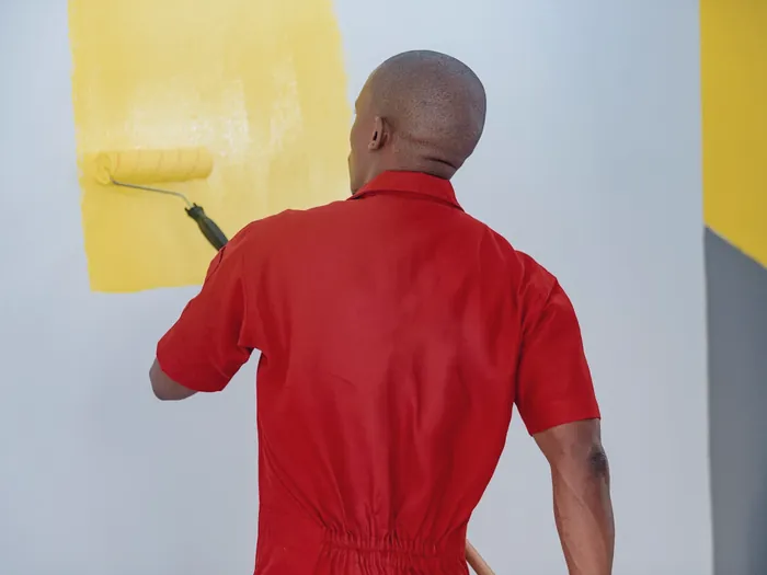 Peintre qui applique un mur au rouleau