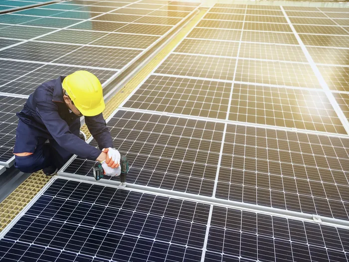Installateur qui fixe des panneaux photovoltaïques