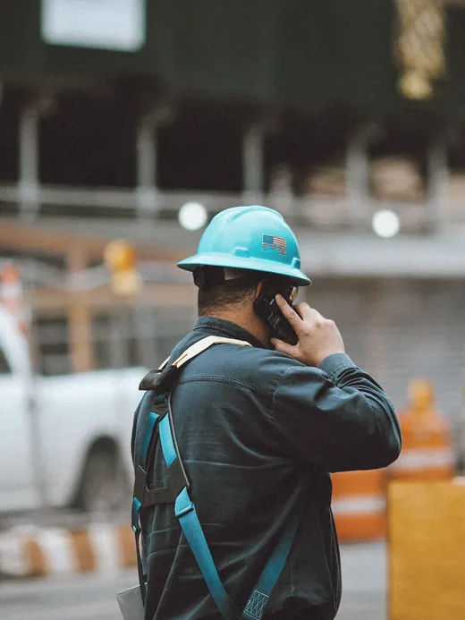 Artisan qui répond au téléphone sur un chantier