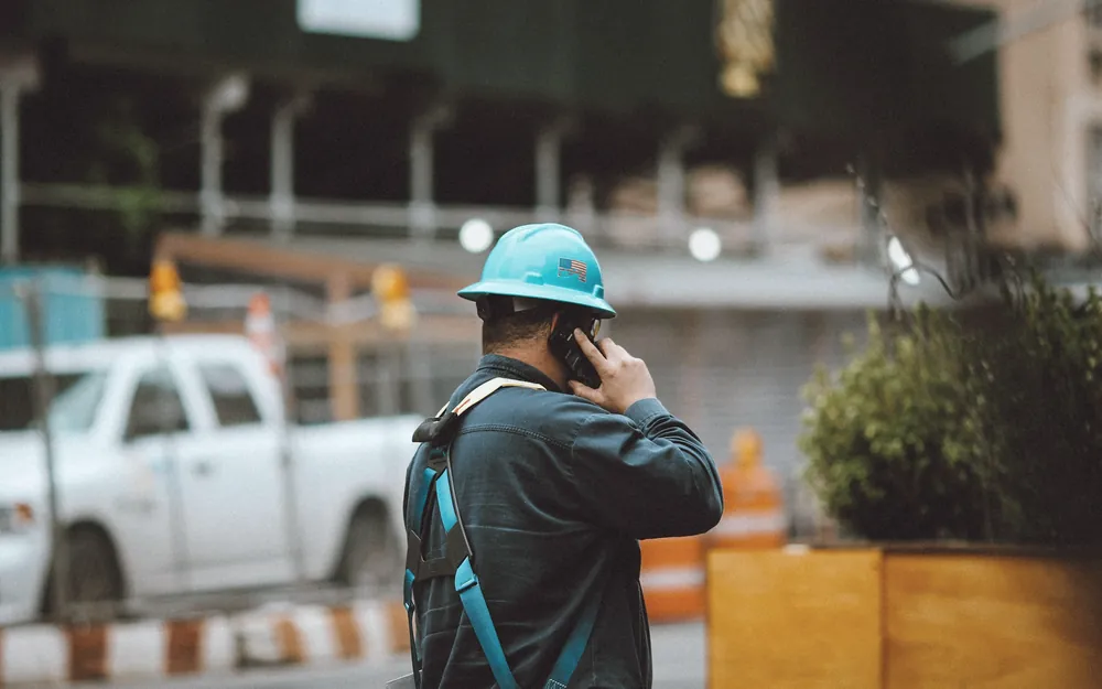 Artisan qui répond au téléphone sur un chantier